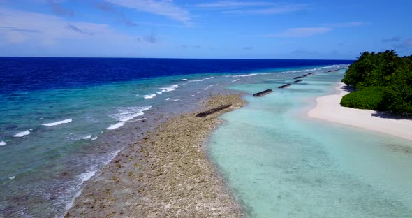 Wide angle fly over tourism shot of a white sandy paradise beach and aqua turquoise water background alt