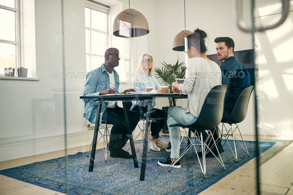 Diverse young businesspeople talking together in an office boardroom - Stock Photo - Images