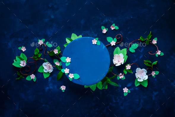 Blooming apple tree branch with a circle template. Dark blue background flat lay with copy space