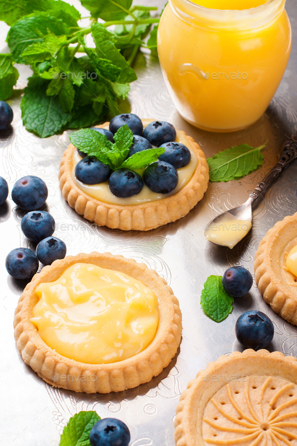 Broken tartlet with lime curd and blueberries Stock Photo by Merinka