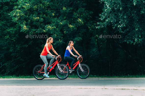 Download Two Women Cycling Together Stock Photo by microgen | PhotoDune