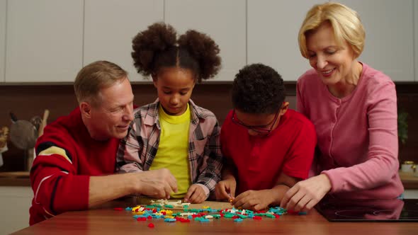 Cheerful Grandparents and Multicultural Kids Playing Sorting Puzzle Game alt