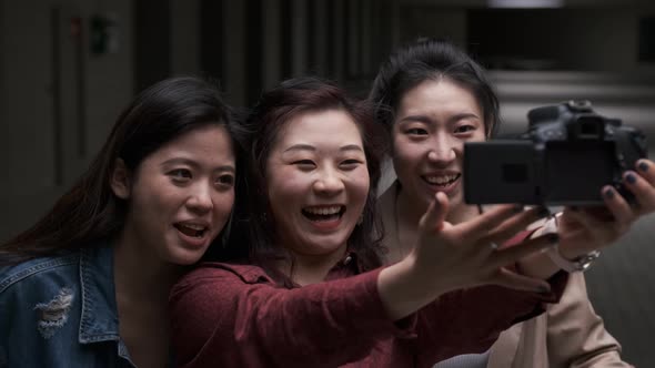 Asian female friends bloggers creating content for social media while making a video with a camera. alt