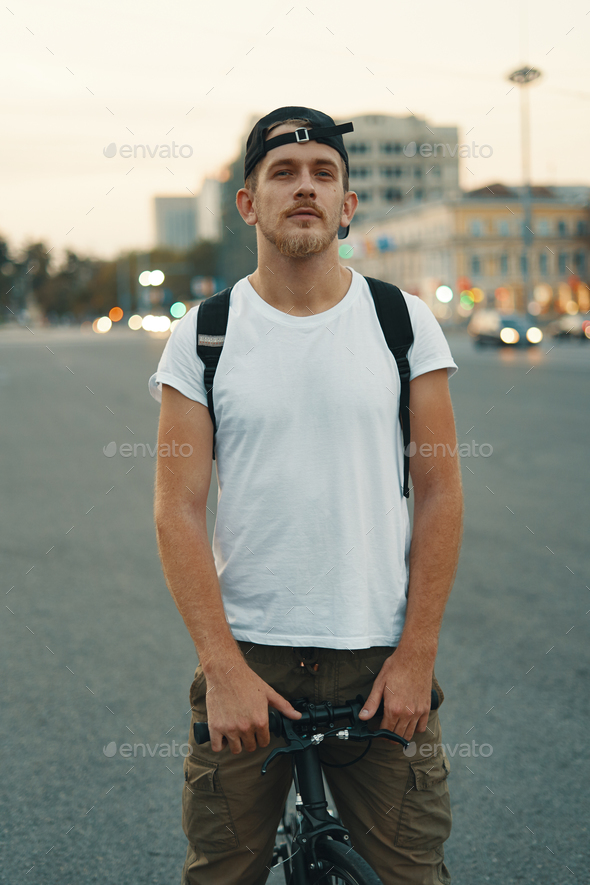 Man riding bicycle in urban city holding hands on handlebar - Stock Photo - Images