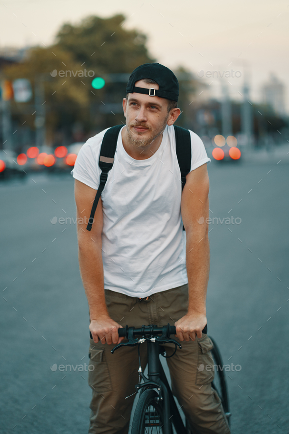 Man riding bicycle in urban city holding hands on handlebar - Stock Photo - Images