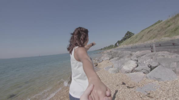 POV Shot of Girl Pulling Boyfriend Along The Beach His Hand in Slowmotion - Ungraded alt