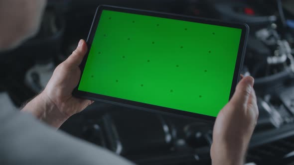 Male Car Service Worker Swiping on Tablet alt