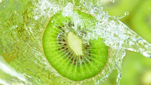Super Slow Motion Shot of Splashing Water on Rotating Kiwi Slice at 1000Fps alt