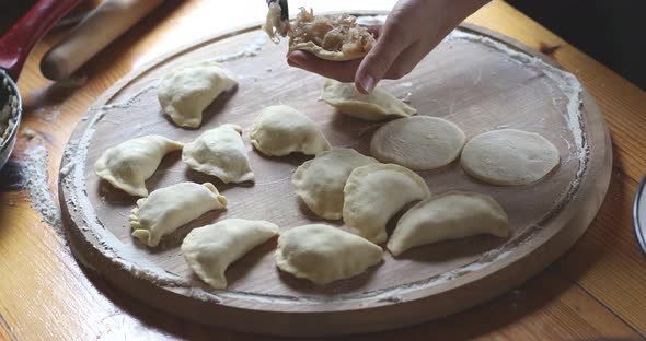 The raw traditional Ukrainian hand-made vareniki (dumpling) with cabbage inside alt