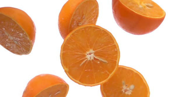 Closeup of Sweet Halves of Orange Falling Diagonally on the White Background alt