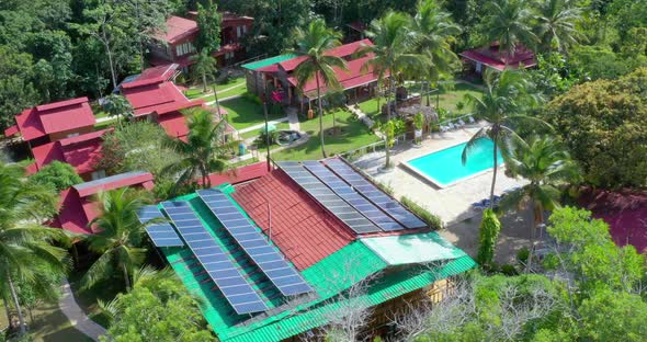 View of red roofs, green tropical landscape, pool and solar panels on rooftop of hotel ecologico Lom alt