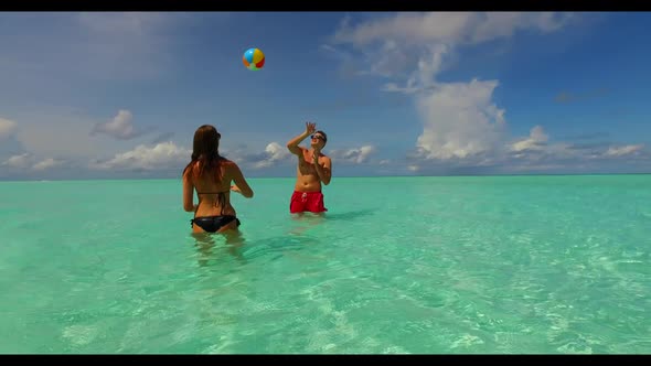 Teenage lovers tanning on exotic seashore beach journey by blue green water with white sand backgrou alt