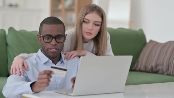 Mixed Race Couple Doing Successful Online Shopping on Laptop alt