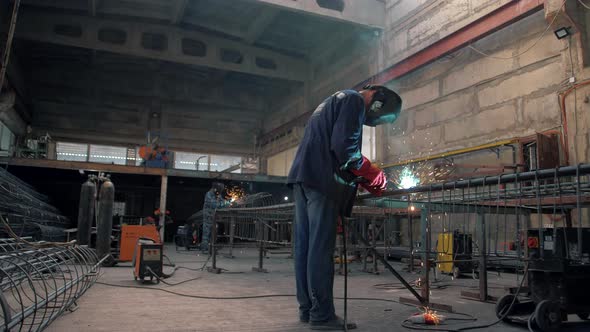 Metalworker workers weld metal in a welding workshop alt