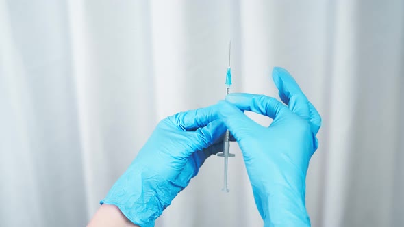 The nurse releases the air from the vaccine syringe