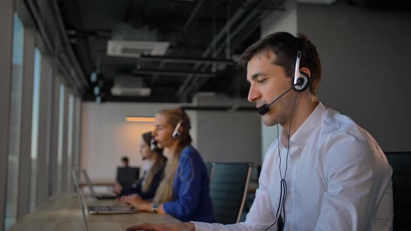 Attractive Worker in Office Call Center Talking with Client and Then Smile To Camera alt