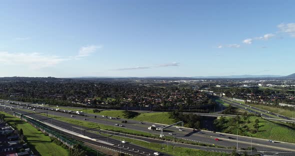 Slow decent over busy highway arterial interchange with many trucks and cars passing heading toward alt