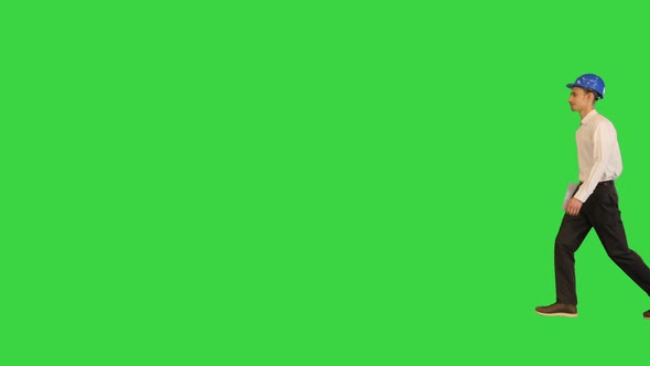 Man with a Blue Helmet Walking Holding Documents on a Green Screen Chroma Key alt