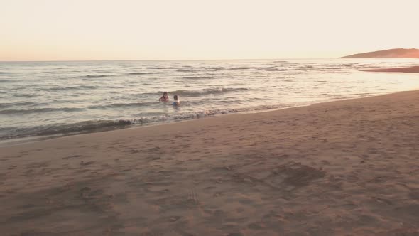 Young Sister and Brother Who Are Playing in the Sea