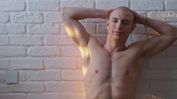Portrait of Handsome Bald Shirtless Adult Gay Man Posing in Font of White Wall alt
