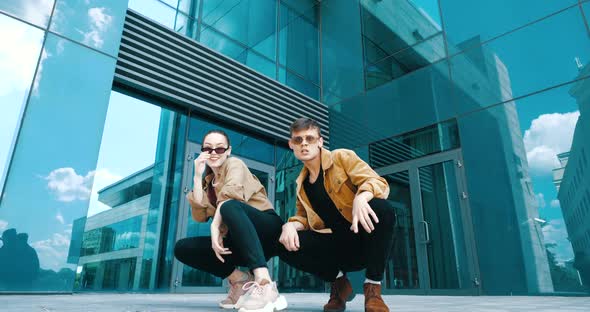 Couple Friends Dancing To Rhythmic Music, Glass Blue Background, Male and Female Young Dancers Move alt