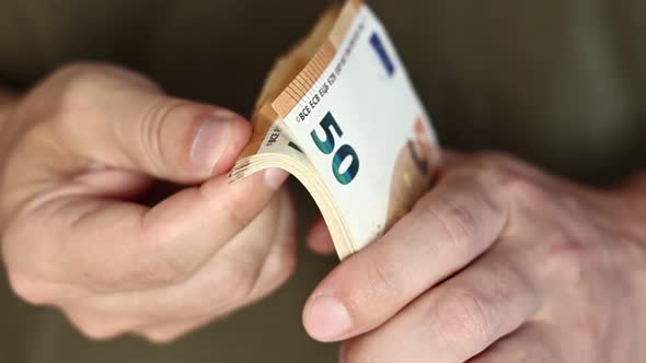 Man Counting Money. Close up of male hands counting pile of 50 euro banknotes. Euro currency exchang