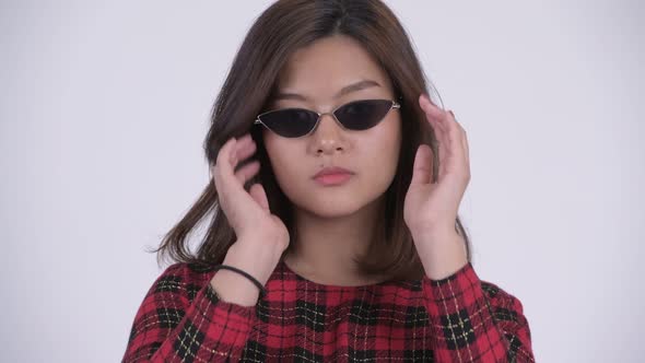 Face of Young Beautiful Asian Businesswoman Peeking Over Sunglasses alt