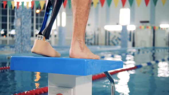 Disabled Swimmer Warms Up Near a Pool, Close Up alt