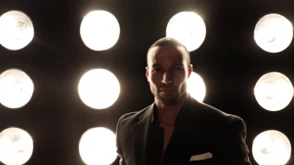 Handsome and stylish man in front of a wall of lights alt