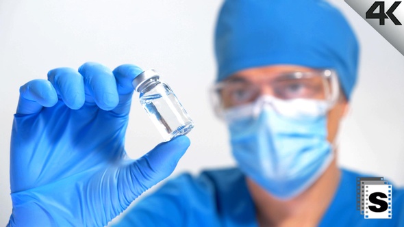 Scientist Looking Vaccine Bottle