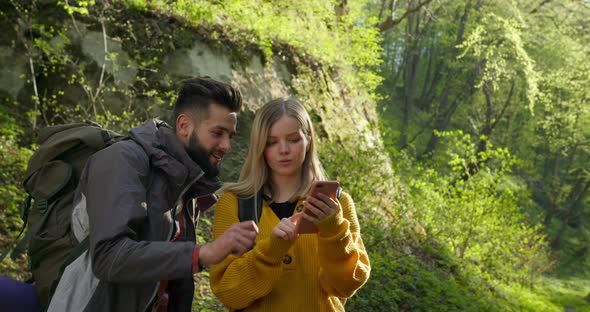 A Guy and a Girl Are Looking at a Map on Their Smartphone alt