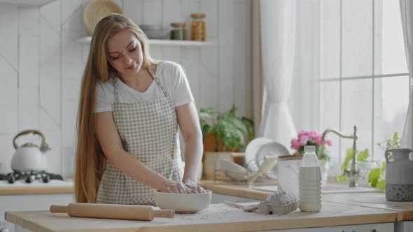 Caucasian Woman with Long Hair Adult Housewife Female Baker Cook Wears Apron Stands in Modern Home alt