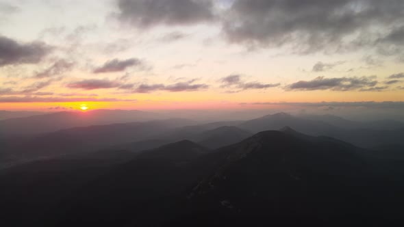 Aerial View of Foggy Evening Over High Peak with Dark Pine Forest Trees at Bright Sunset alt