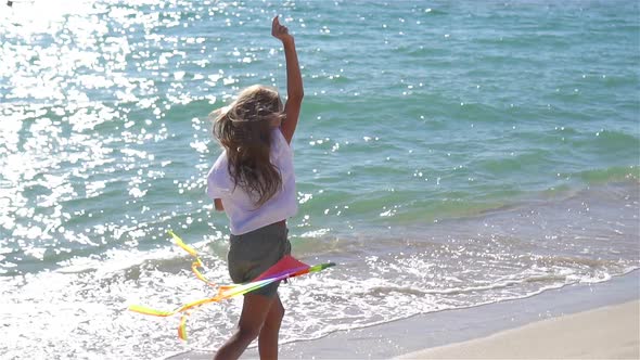 Little Girl Flying a Kite on Beach at Sunset