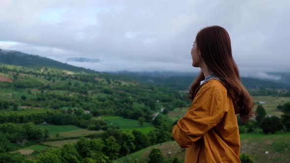 A female traveler looking at a beautiful green mountains view