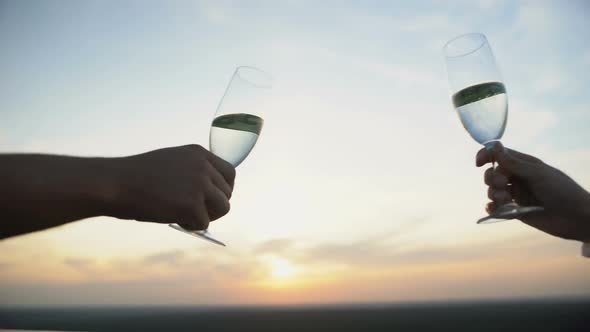 Couple Clinking Champagne Glasses Against Sunset Background, Romantic Date