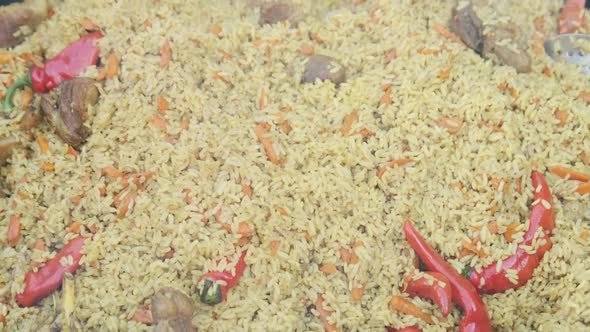 Big Vat with Cooked Pilaf or Rice Over an Open Fire. Street Food at the Party alt