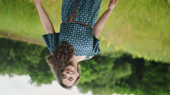 Attractive Curly Blond Woman Posing at Camera Happy Smiling Walking on Green Grass in Nature Outside alt