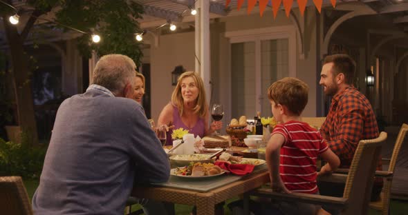 Three generation family enjoying lunch outdoors alt