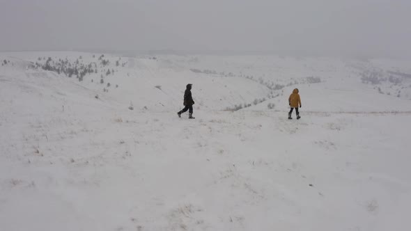 Two Men Climbed the Top of the Mountain Covered with Snow During the Fog