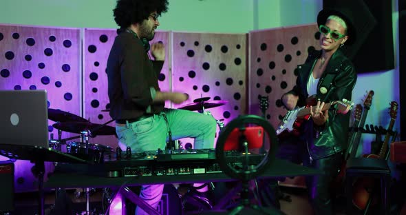 Young people playing music inside a recording studio alt