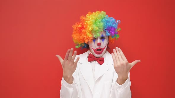 A Happy Clown Grimaces in Front of the Camera on an Isolated Background