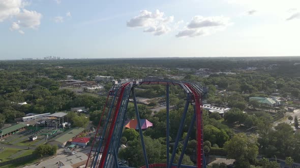 People riding an extreme roller coaster in theme park in Tampa, Florida Busch Gardens. Aerial view alt