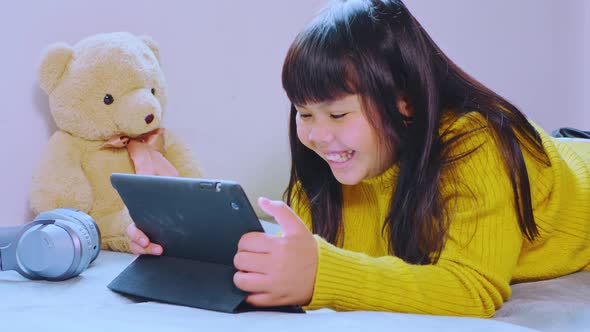 Asian girls study online and watch the tablet at home
