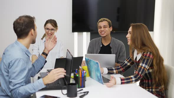 Happy Creative Business People with Laptops in the Office Disscusing Project Together alt