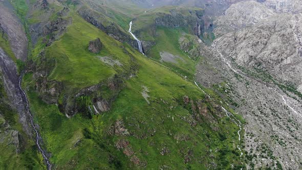 Highland Landscape with Rocks Green Slopes and Waterfall alt