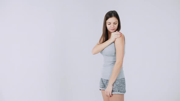 Young Woman Has Pain in the Shoulder, Pain in the Joints, Isolated on a White Background alt