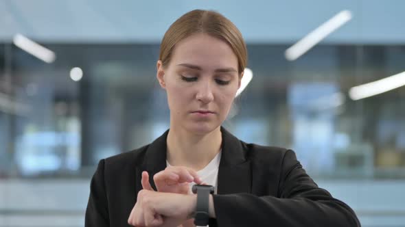 Businesswoman Using Smartwatch for Information alt
