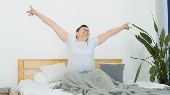 Senior Woman Wakes Up in the Morning in a Light Room alt