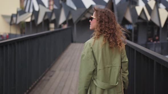 A Young Stylish Woman Walks on a Pedestrian Bridge an Art Space in Modern City